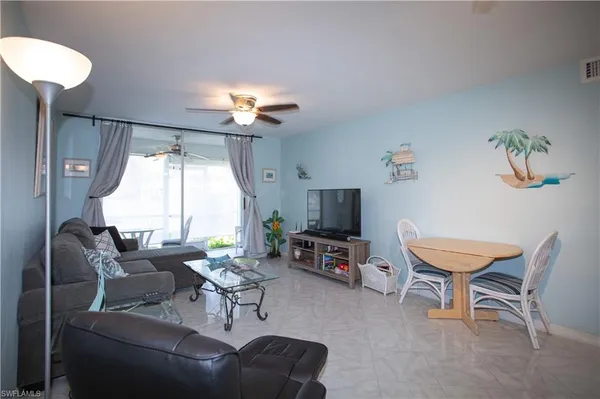 a living room with furniture a ceiling fan and a window