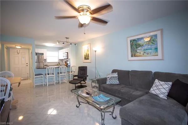 a living room with furniture a ceiling fan and a rug