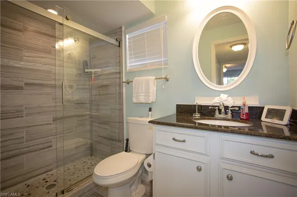 a bathroom with a toilet a sink and mirror
