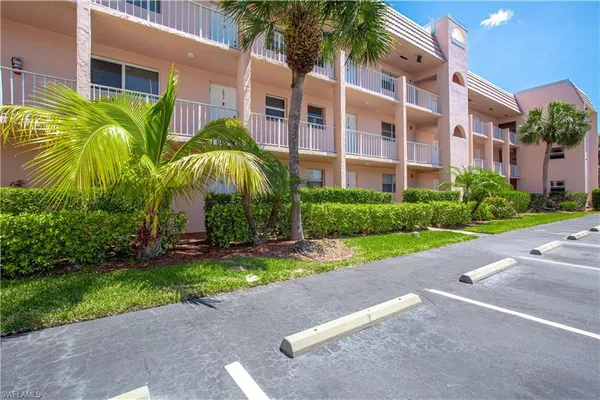 a view of a building with a yard and potted plants