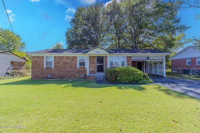 a front view of a house with yard and green space