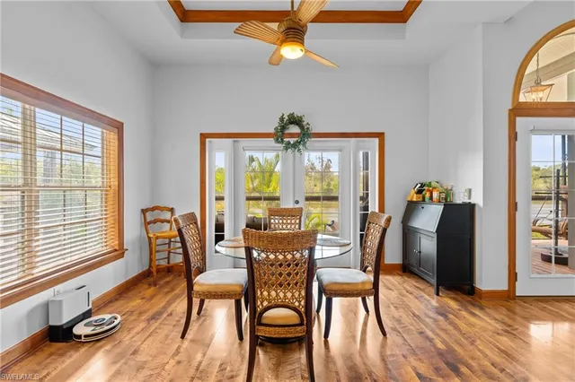 a dining hall with stainless steel appliances granite countertop a stove and a dining table with chairs