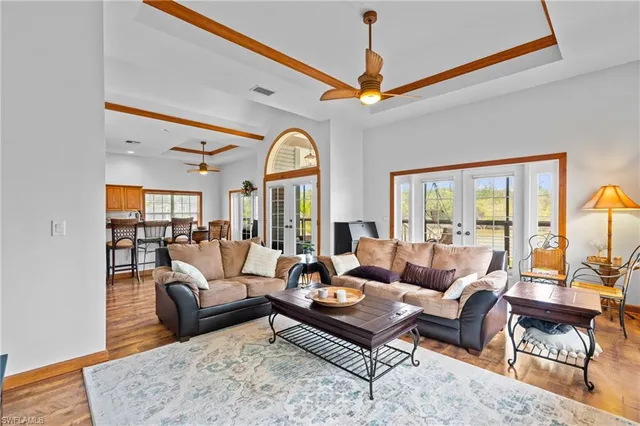 a living room with furniture a ceiling fan and a large window