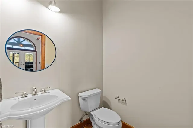 a bathroom with a toilet sink and mirror