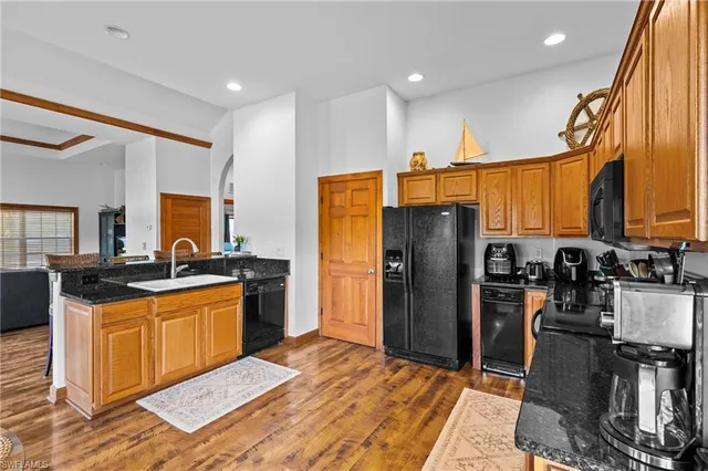 a kitchen with stainless steel appliances granite countertop a refrigerator a stove and a sink