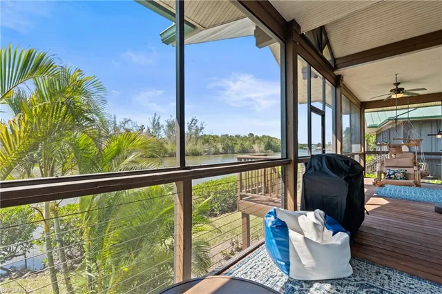 a view of a living room with a floor to ceiling window and wooden floor