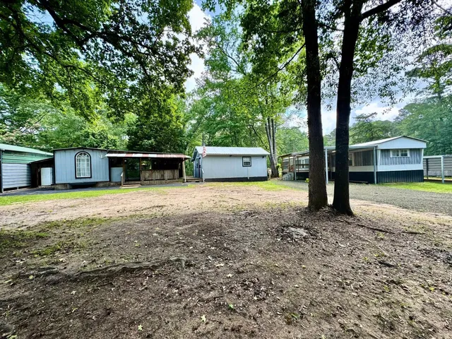a front view of a house with a garden and trees