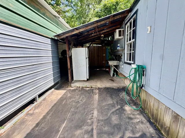 a view of a house with a yard and a large tree