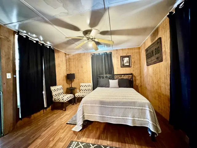 a bedroom with a large bed and wooden floor