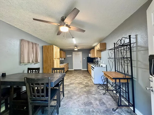 a large kitchen with stainless steel appliances kitchen island granite countertop a stove refrigerator and cabinets