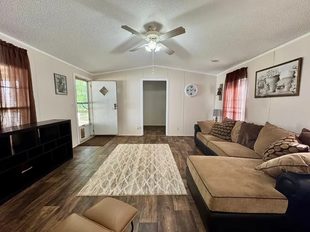 a living room with furniture ceiling fan and a window