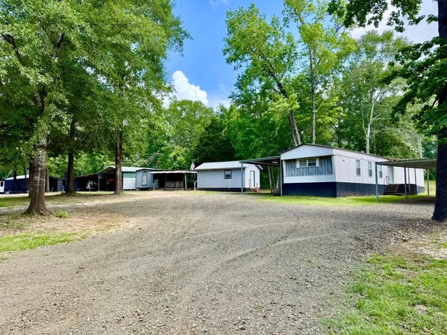 a front view of a house with a yard and trees