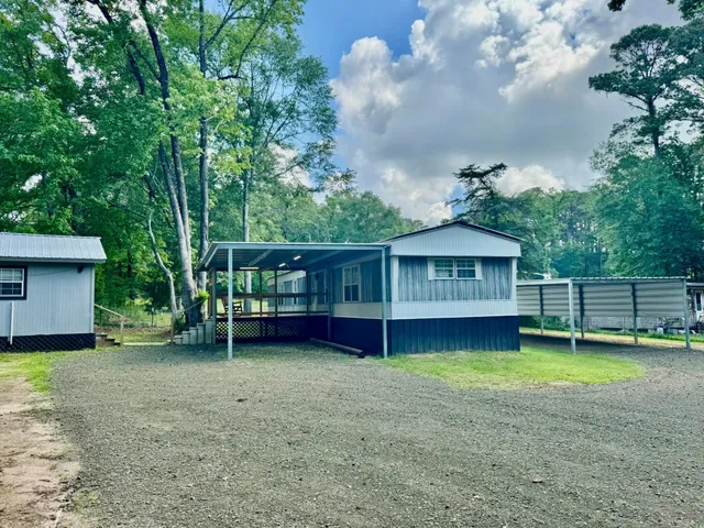 a view of a house with a yard potted plants and a tree