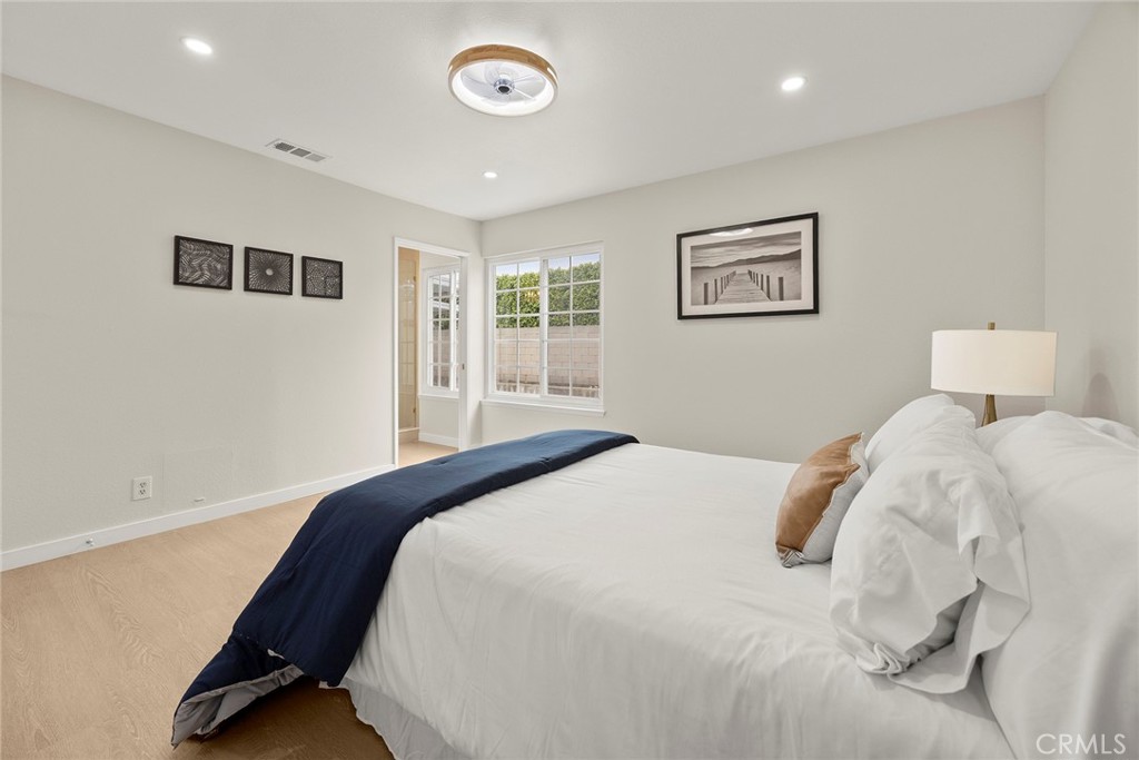 11524 Jerry Street Cerritos, CA 90703 - Photo 15 of 31 The primary bedroom features two large windows that overlook the pool, filling the room with natural light and offering a peaceful view of the backyard.