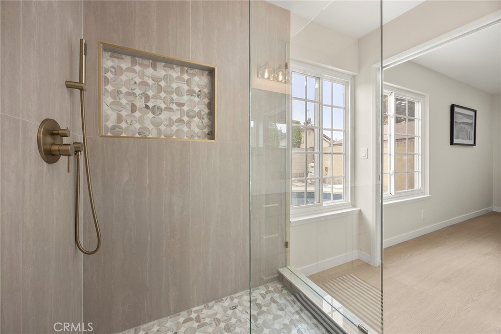 11524 Jerry Street Cerritos, CA 90703 - Photo 18 of 31 The remodeled primary en-suite bathroom includes a decorative tiled niche, a thoughtful design detail that adds character and convenient storage while enhancing the space’s modern appeal.