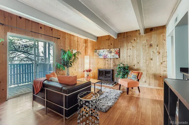 a living room with furniture a fireplace and a floor to ceiling window