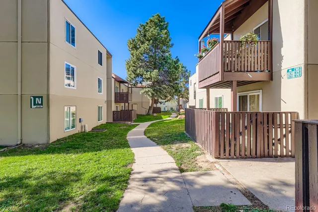 a view of a brick house with many windows next to a yard