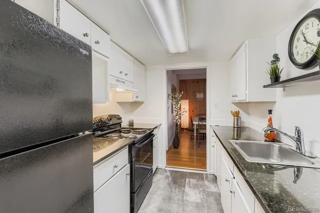 a kitchen with a sink stove top oven and cabinets