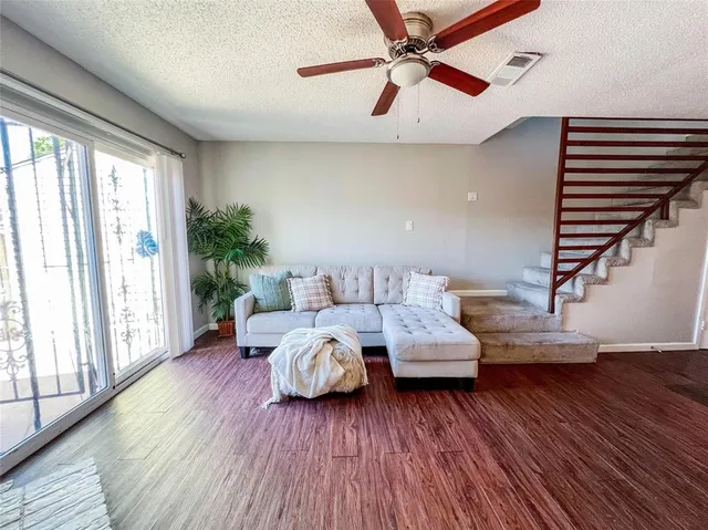 a living room with furniture and wooden floor
