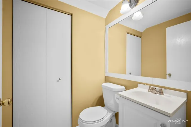 a bathroom with a sink mirror vanity and toilet