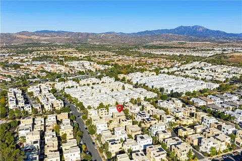 an aerial view of residential houses with outdoor space and trees