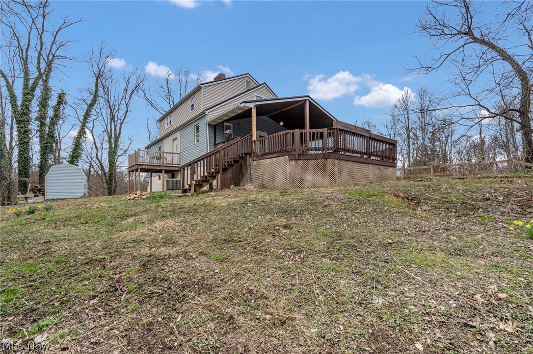 1781 Grace Road Akron, OH 44312 - Photo 24 of 26 Back of property featuring a deck, a storage shed, and a yard
