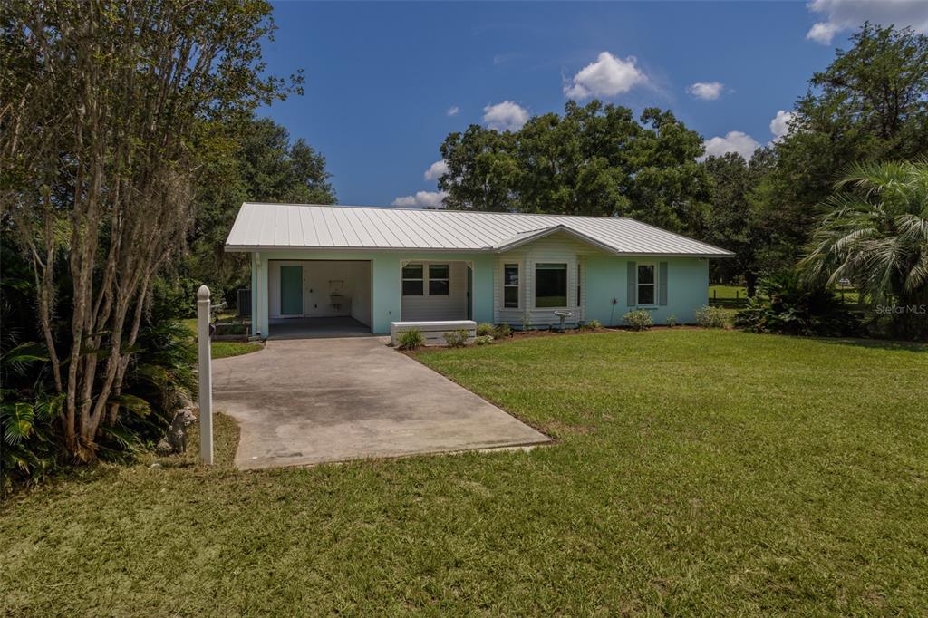 13905 Southwest 143rd Street Archer, FL 32618 - Photo 1 of 1 a front view of a house with a yard and trees