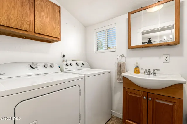 a utility room with sink dryer and washer