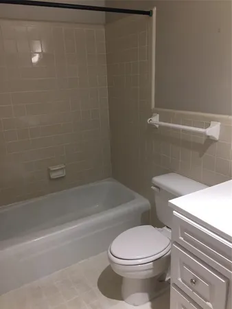a white toilet sitting next to a bath tub
