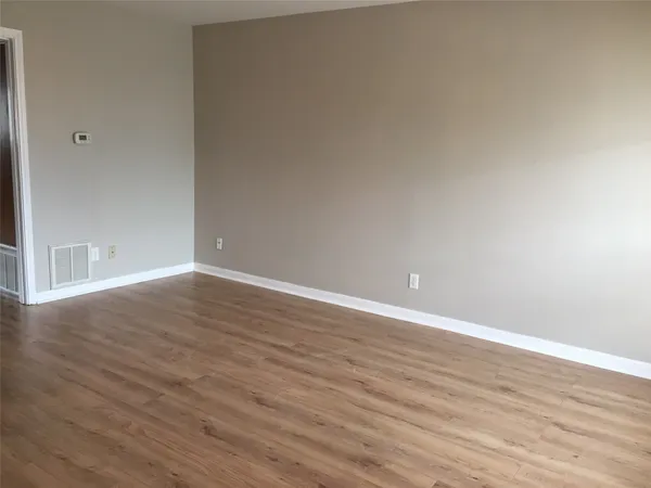 a view of a room with wooden floor