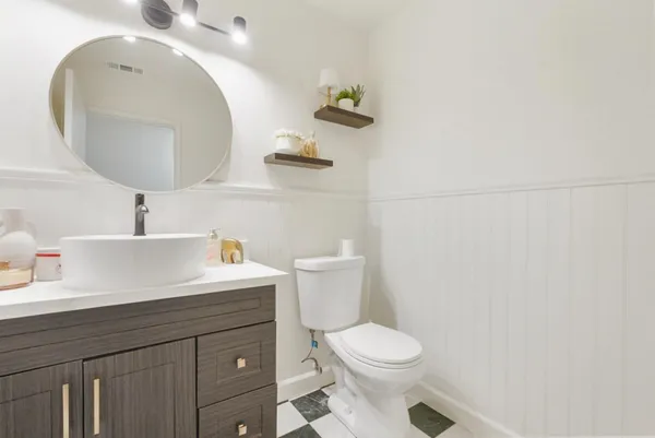 a bathroom with a sink a toilet and a mirror