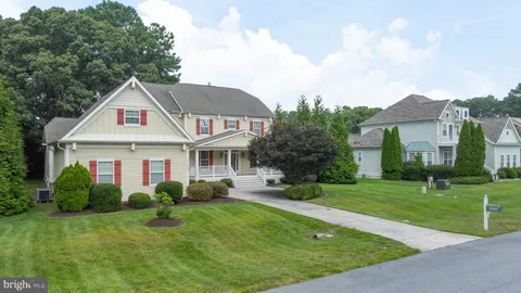 a view of a house with a big yard plants and large trees