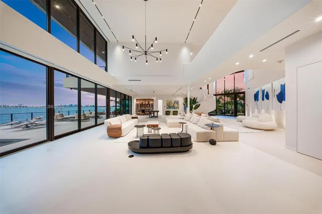 a living room with couches and projector with kitchen view