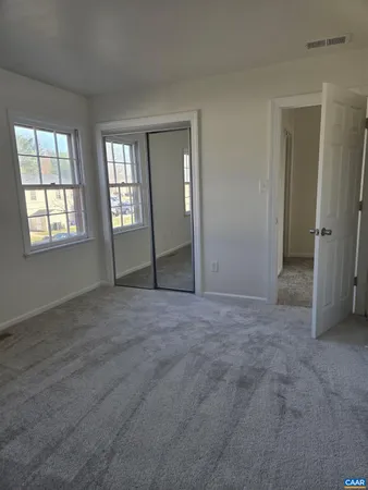 an empty room with windows and closet