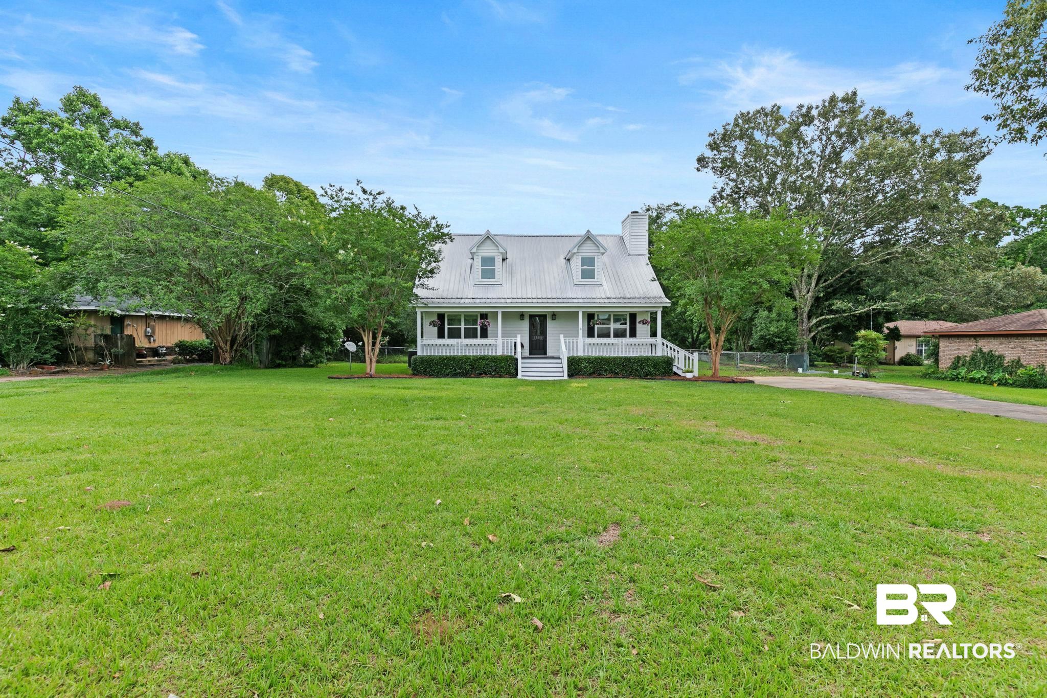 22810 High Ridge Road Fairhope, AL 36532 - Photo 6 of 78 White two-story residence featuring a metal roof, front porch with white railing, and exterior chimney