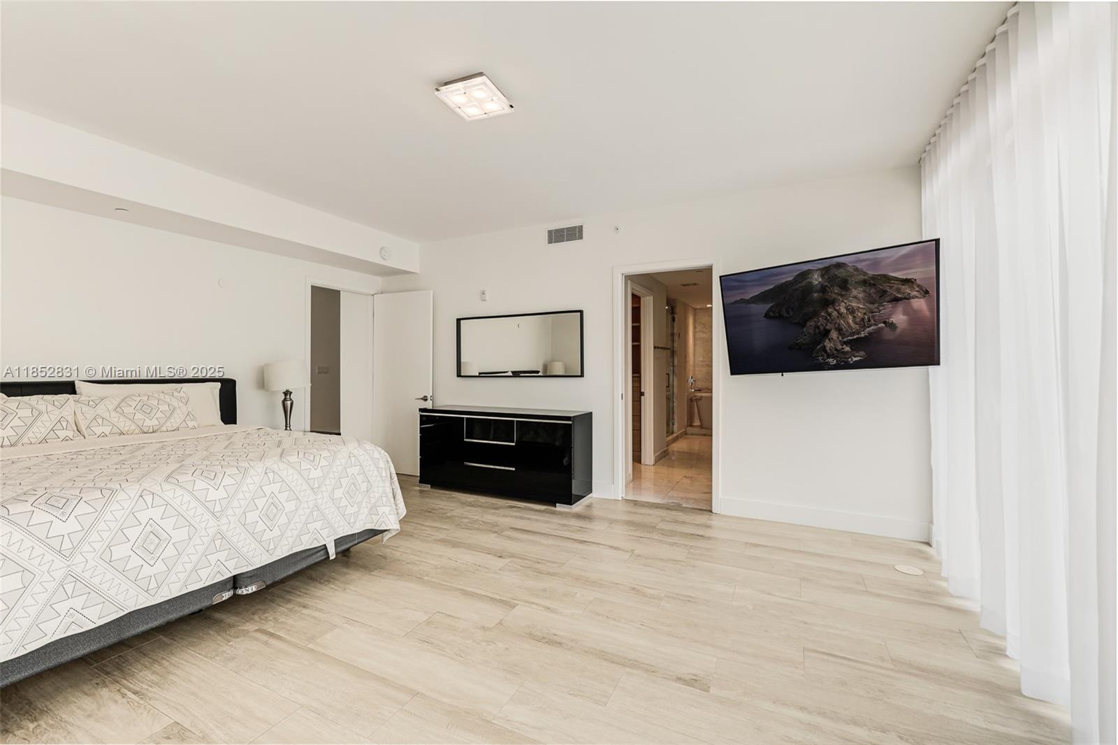 2101 South Surf Road, Unit 2F Hollywood, FL 33019 - Photo 54 of 70 a spacious bedroom with a bed and a flat screen tv
