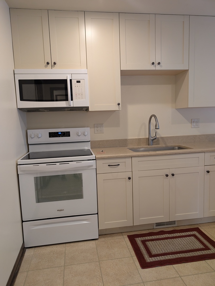 1535 Wedgefield Circle, Unit 1535 Naperville, IL 60563 - Photo 11 of 46 a kitchen with white cabinets appliances and sink