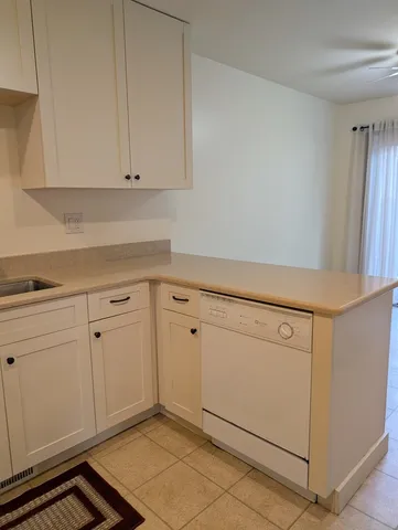 a kitchen with white cabinets and white appliances