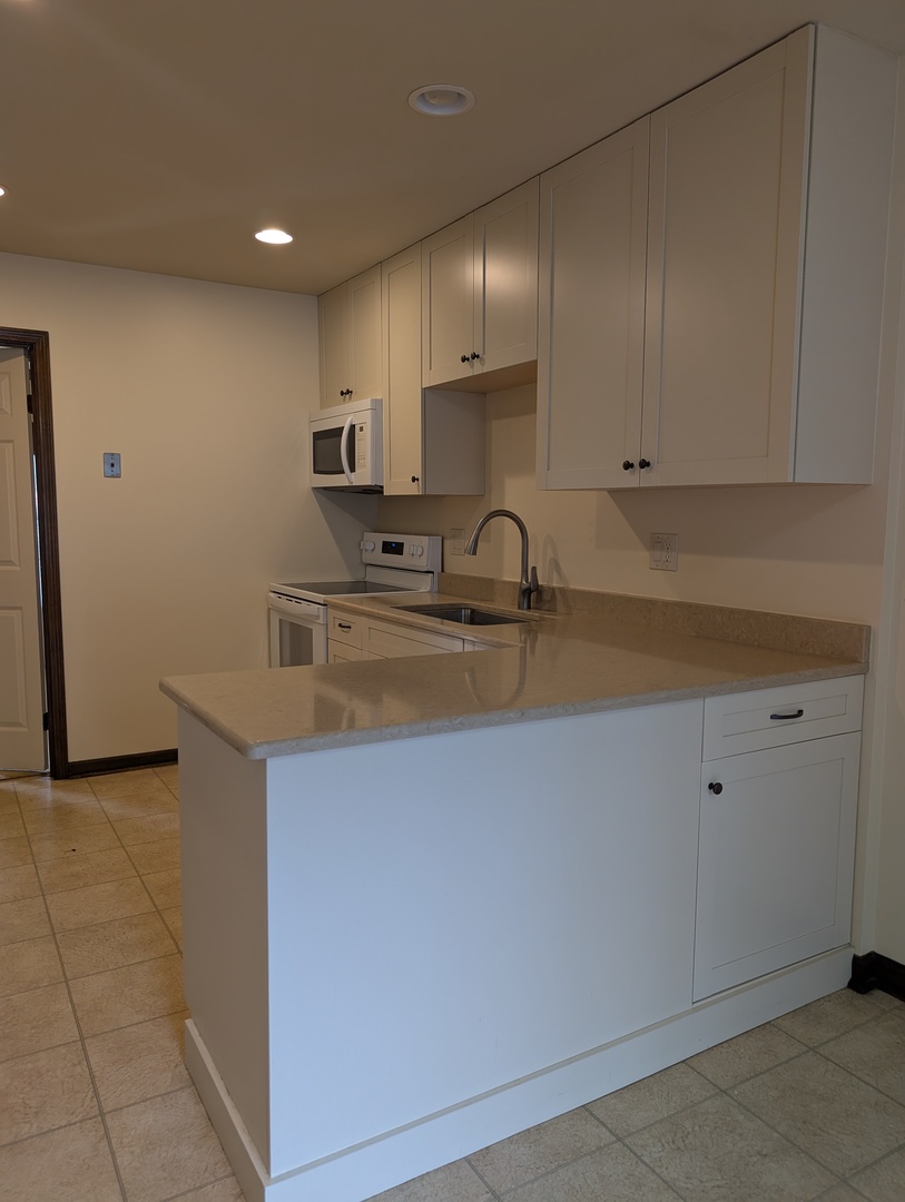 1535 Wedgefield Circle, Unit 1535 Naperville, IL 60563 - Photo 14 of 46 a kitchen with kitchen island sink stove and cabinets