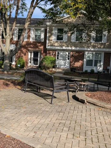 a view of a deck with a bench and large trees