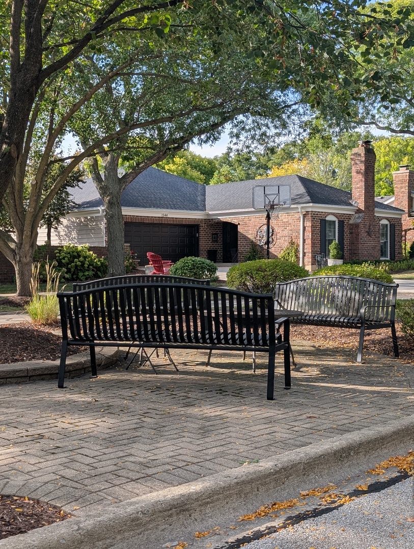 1535 Wedgefield Circle, Unit 1535 Naperville, IL 60563 - Photo 45 of 46 a view of a deck with a bench and large trees