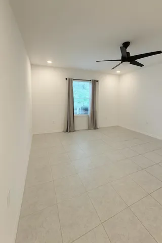 an empty room with windows and fan