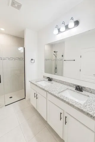 a bathroom with a granite countertop sink mirror and shower