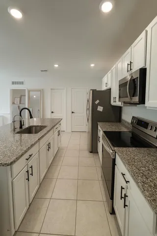 a kitchen with stainless steel appliances granite countertop a sink and a stove