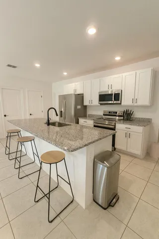 a kitchen with stainless steel appliances granite countertop a stove a sink a microwave and a refrigerator