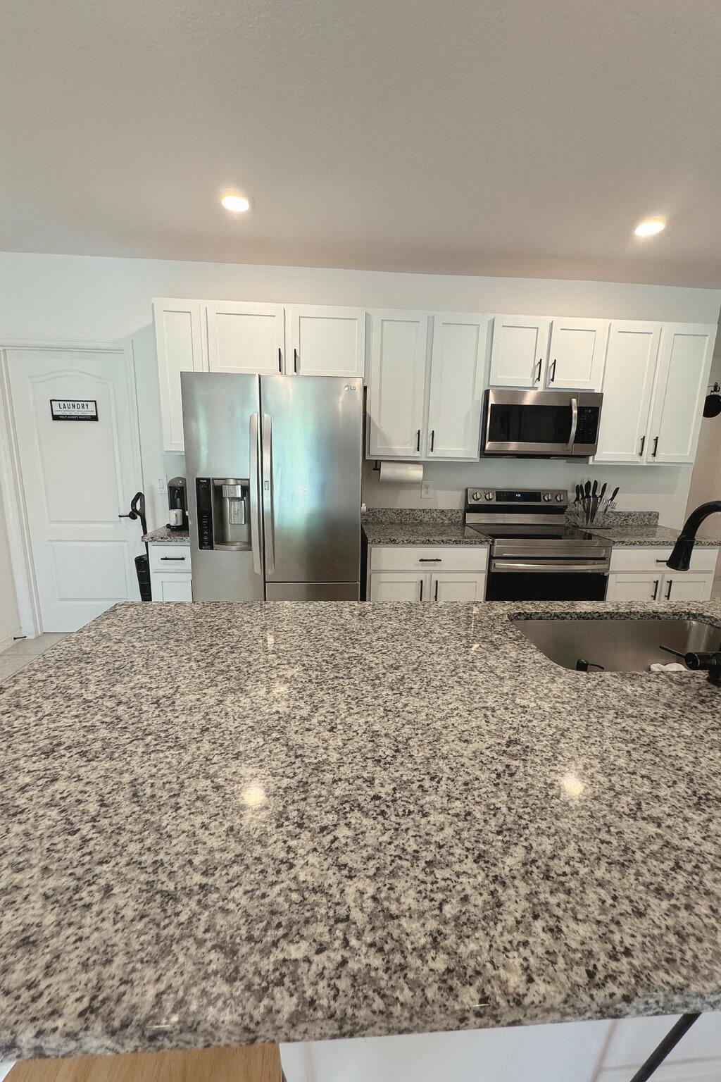 1963 Southwest Import Drive Port St. Lucie, FL 34953 - Photo 7 of 39 a kitchen with kitchen island a stove a refrigerator and a sink