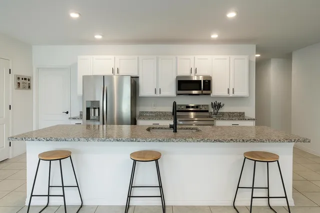 a kitchen with stainless steel appliances granite countertop a stove top oven a sink and a granite counter tops