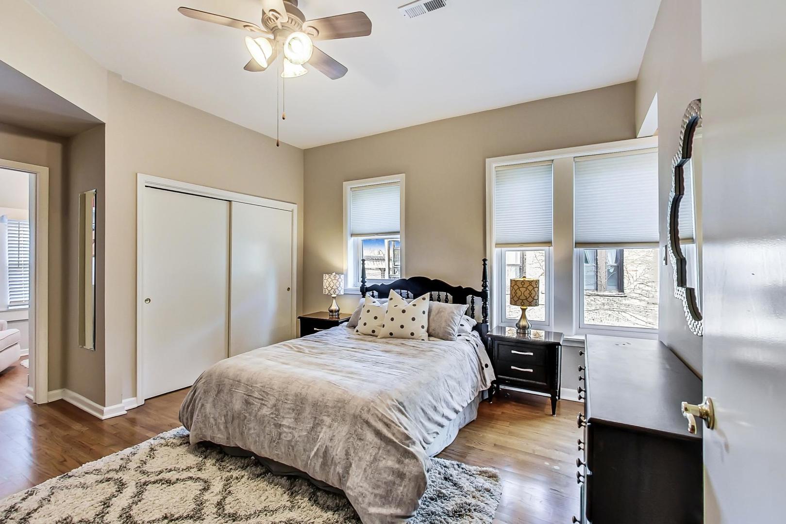 4214 North Kenmore Avenue, Unit 2F Chicago, IL 60613 - Photo 14 of 23 a bedroom with a bed and a chandelier