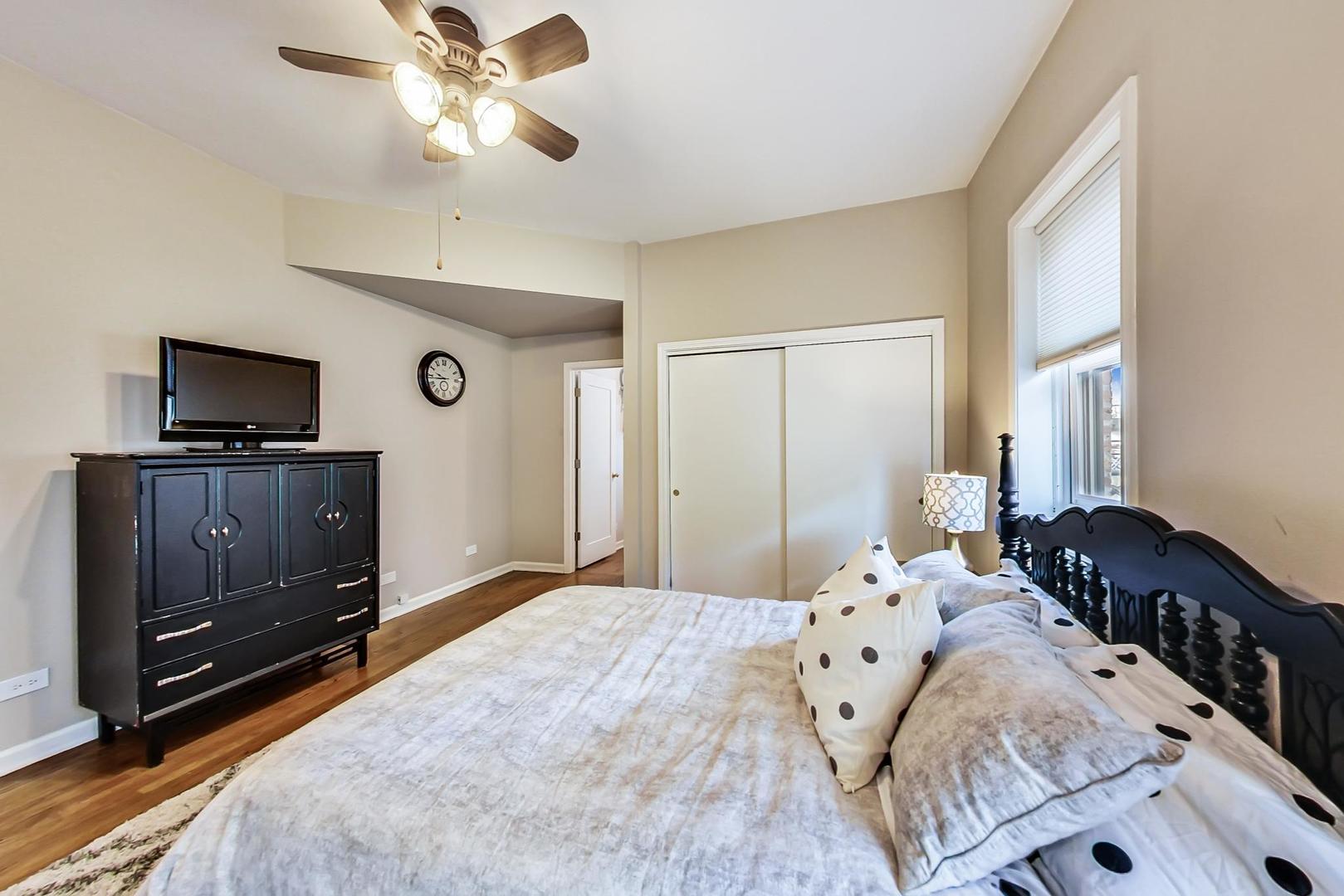 4214 North Kenmore Avenue, Unit 2F Chicago, IL 60613 - Photo 16 of 23 a bedroom with a bed and a flat tv screen on dresser