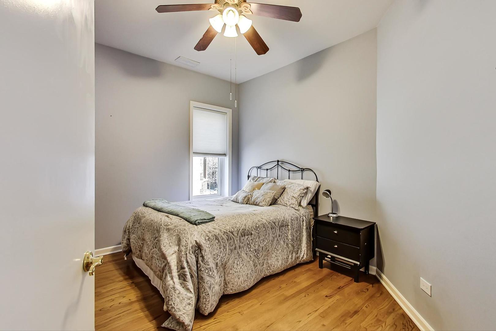 4214 North Kenmore Avenue, Unit 2F Chicago, IL 60613 - Photo 20 of 23 a bedroom with a bed and a chandelier